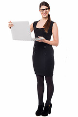 Image showing Smart corporate lady holding a laptop