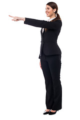 Image showing Corporate smiling woman pointing at something