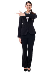 Image showing Attractive corporate woman pointing away