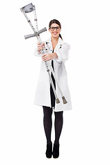 Image showing Smiling medical expert holding pair of crutches