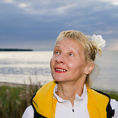 Image showing Woman looks at a cloudy sky at the sea