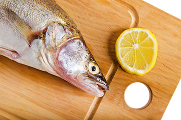 Image showing Pike perch on a wooden kitchen board, it is isolated on white