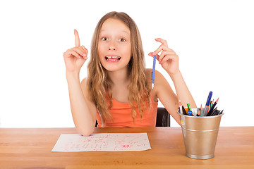 Image showing Child sitting at a table found an idea to draw