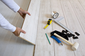 Image showing Worker laying laminated