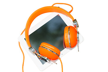 Image showing White tablet computer with orange headphones isolated on white
