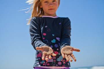 Image showing Young girl with sand covered hands