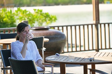 Image showing Beautiful young woman with a drink by the sea