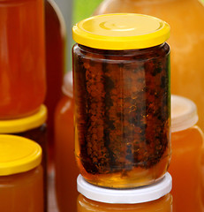 Image showing A honeycomb and a honey in a glass jar