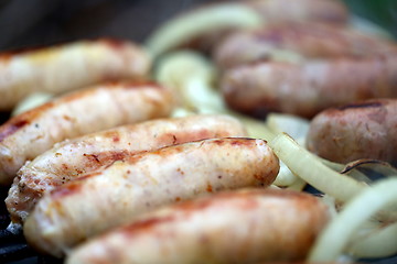 Image showing BBQ a lot of sausages with onion