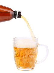 Image showing Close up of bottle of beer pouring into a mug.