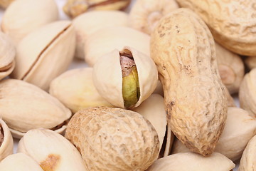 Image showing One open pistachio and peanuts