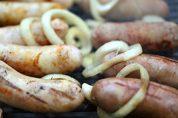 Image showing BBQ a lot of sausages with onion