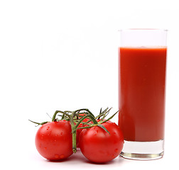 Image showing Tomato juice in glass with a cluster of small tomatoes