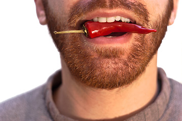 Image showing man with a red hot chili pepper in his mouth