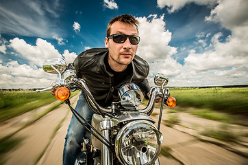 Image showing Biker racing on the road