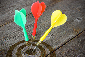 Image showing Darts hitting  target on a wooden planks