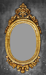 Image showing Old-fashioned gilt frame for a mirror on a concrete wall