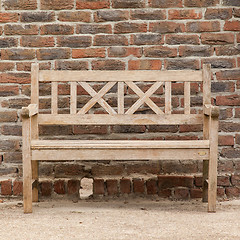 Image showing Rugged, primitive wooden sidewalk bench beside multi-colored ver