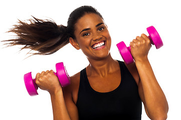 Image showing Happy fitness woman lifting dumbbells