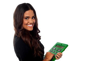 Image showing Businesswoman operating big green calculator