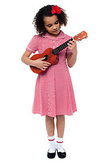 Image showing Preschool cute girl playing a guitar