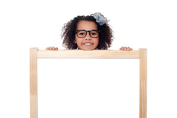 Image showing Girl peeping from behind white writing board