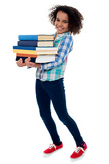 Image showing Active young school kid carrying books