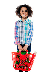 Image showing Happy school girl carrying stationery in basket