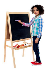 Image showing Happy schoolchild writing on blackboard