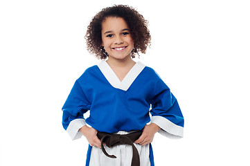 Image showing Little girl adjusting her brown karate belt