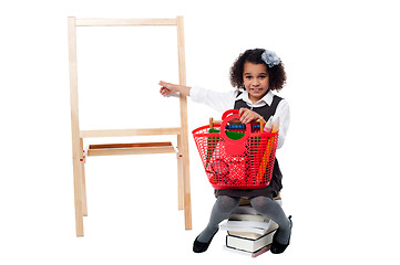 Image showing Young cute kid sitting on a pile of books