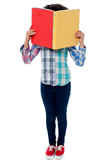 Image showing School girl hiding her face with a book