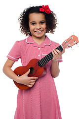 Image showing A little girl with a toy guitar