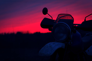 Image showing Silhouette of motorbike against sunset sky