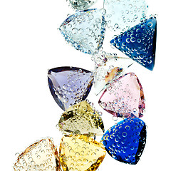 Image showing Multi-colored gems falling into water isolated on white.
