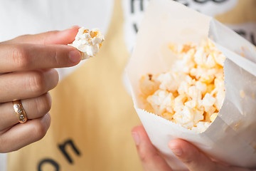 Image showing Close up eating butter popcorn from popcorn pack 