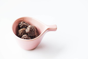 Image showing Sweet dry pink plum in ceramic cup 