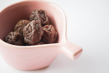 Image showing Sweet dry pink plum in cup up close