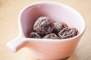 Image showing Delicious dry pink plum in cup up close 