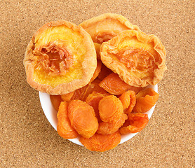 Image showing Dried apricots and peaches on cork board