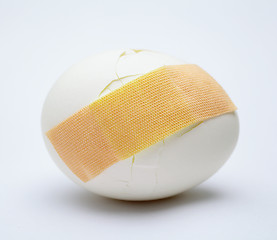 Image showing Cracked white egg with plastic plaster