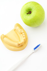 Image showing Green apple, toothbrush and denture