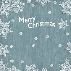 Image showing Christmas greetings with snowflakes on wooden texture. Vector il