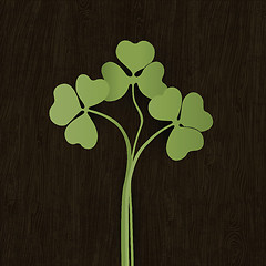 Image showing Clover leaves on wooden weathered texture. Vector, EPS10.