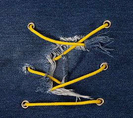 Image showing Blue jean with hole and crisscross lacing