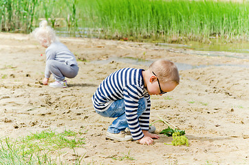 Image showing  Boy and girl playing in the sand on the shore of Lake 