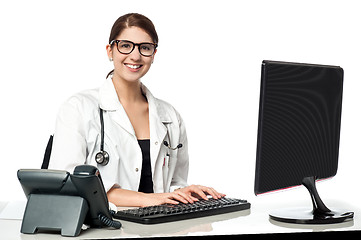 Image showing Smiling female doctor working on computer
