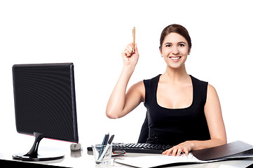 Image showing Businesswoman holding pen and raising her hand