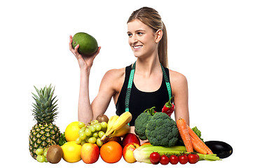 Image showing Attractive girl with heap of fruits and vegetables