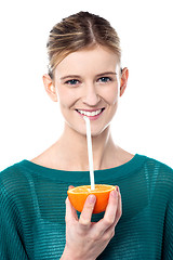 Image showing Girl sipping orange juice through straw